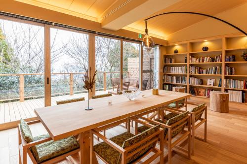 a dining room with a large wooden table and chairs at Suite Villa Curation Atami Momoyamagaen in Atami