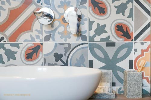 a bathroom with a sink and a tile wall at Art House Arsenale in Turin