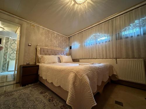 a bedroom with a bed and a chandelier at TAHTAKALE KONAK HOTEL Private & Luxury in Bursa