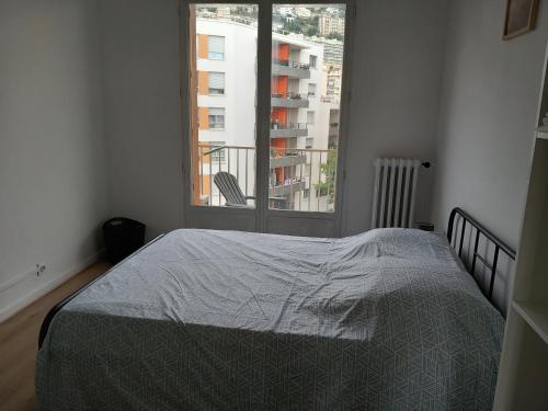 une chambre avec un lit et une fenêtre dans l'établissement Appartement cosy Nice, à Nice