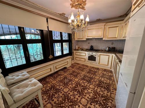 a kitchen with a chandelier and a table and chairs at TAHTAKALE KONAK HOTEL Private & Luxury in Bursa