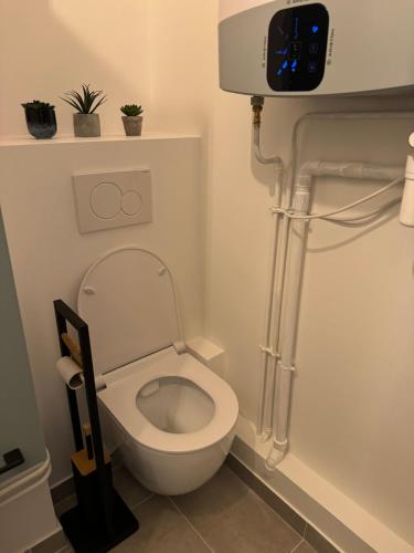 Un baño con inodoro y un reloj en la pared. en Appart proche Paris Disney Bercy , Parking, en Joinville-le-Pont