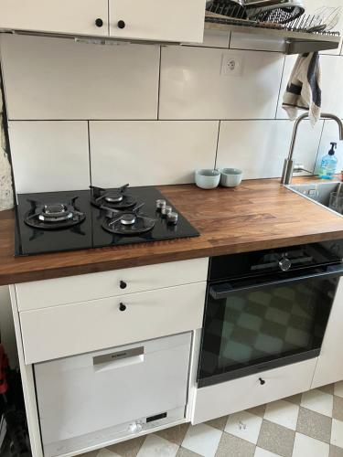 une cuisine blanche avec une cuisinière et un évier dans l'établissement Appartement 35m2, à Aubervilliers