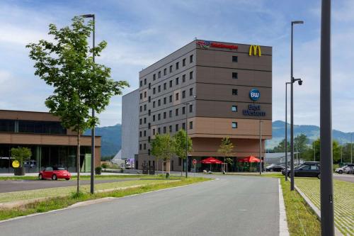 a building with a sign on the side of a road at Best Western Hotel Kiefersfelden in Kiefersfelden