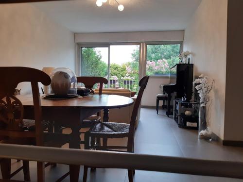 une salle à manger avec une table et des chaises et une fenêtre dans l'établissement Duplex 105m2 pour les JO 2024 entre Paris et Versailles, à Marly-le-Roi