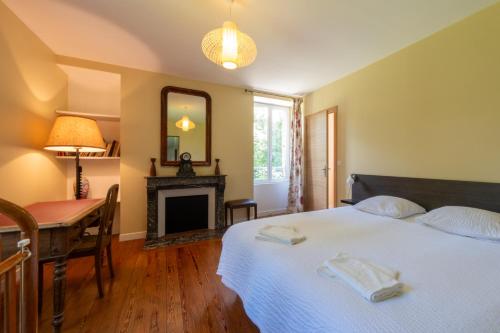 une chambre avec un lit, un bureau et un miroir dans l'établissement Maison de Maître - calme-campagne-nature- CAUTION OBLIGATOIRE SWIKLY, à Cernoy-en-Berry