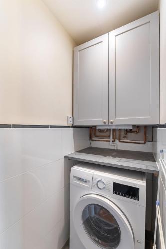 a laundry room with a washing machine and cabinets at The Blue Duck in Hawkshead