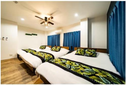 four beds in a room with a ceiling fan at 64, Shiomi , Second floor of the apartment, 潮見2F in Tokyo