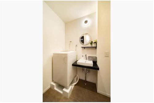 a bathroom with a sink and a toilet and a mirror at 64, Shiomi , Second floor of the apartment, 潮見2F in Tokyo
