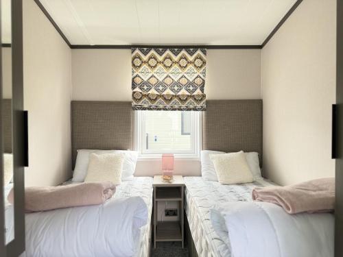 zwei Betten in einem Zimmer mit Fenster in der Unterkunft Stewarts Resort Lodge 41 in St Andrews