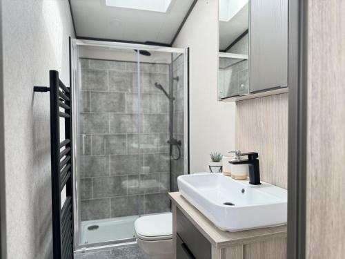 ein Badezimmer mit Toilette, Waschbecken und Dusche in der Unterkunft Stewarts Resort Lodge 41 in St Andrews