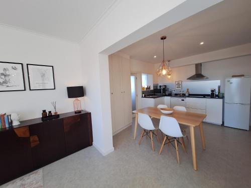 a kitchen and dining room with a table and chairs at Mostarda Boutique Apartment in Vila do Conde