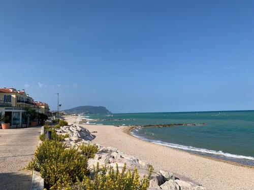 a beach with rocks and the ocean on a sunny day at Casa Vacanze Un passo dal Mare in Porto Recanati