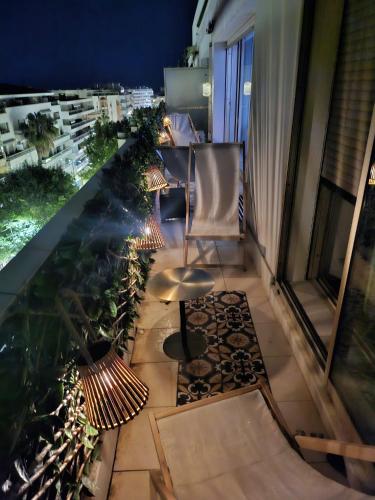 a balcony with a table and chairs on a building at Le Duplex in Antibes