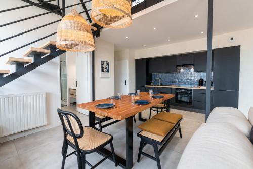 une cuisine et une salle à manger avec une table et des chaises en bois dans l'établissement Kasa Madura - Duplex au calme tout équipé, à Saint-Étienne