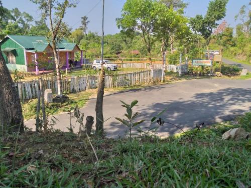 a view of a road with a fence and a house at Rb guest house in Mawlynnong