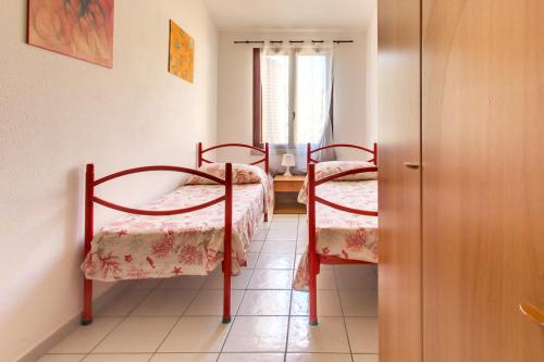 a room with two beds and a window at Residence Oasi Anfiteatro in Porto Ottiolu
