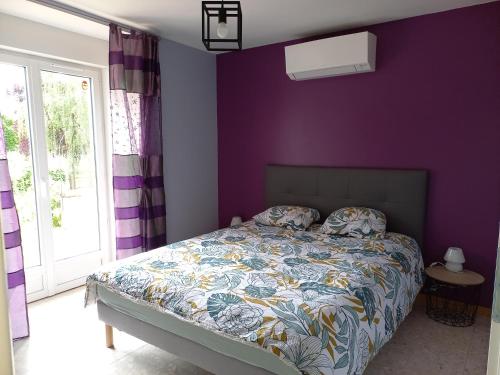 - une chambre avec des murs violets et un lit avec un couvre-lit coloré dans l'établissement Gîte Au Val d'Auxois, à Athie