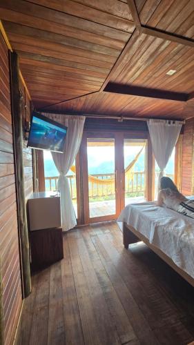ein Schlafzimmer mit Bett und Flachbildfernseher in der Unterkunft Chacara da Sorte in Pacoti