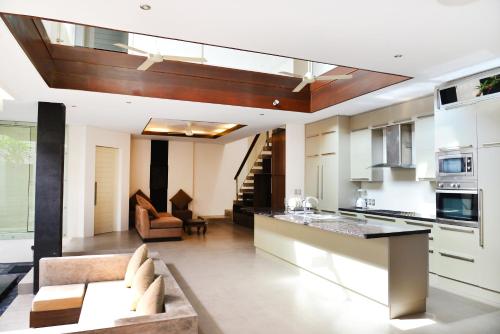een keuken en een woonkamer met een bank en een tafel bij Villa Tentrem Legian in Legian