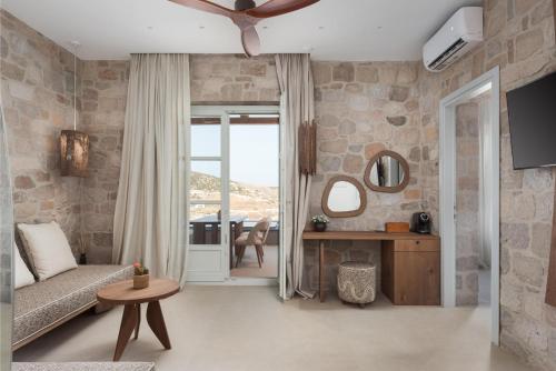 a living room with a couch and a ceiling fan at Horizon Suites Milos in Paliochori