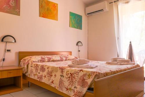 a bedroom with a bed with towels on it at Residence Oasi Anfiteatro in Porto Ottiolu