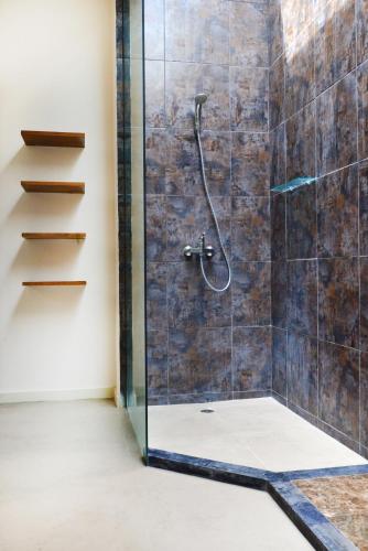 a bathroom with a shower with a glass door at Villa Tentrem Legian in Legian