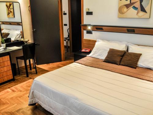 - une chambre avec un grand lit et un bureau dans l'établissement Cristal Palace Hotel, à Andria
