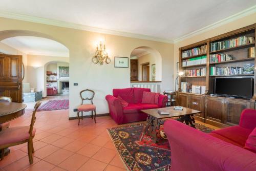 a living room with red furniture and a tv at Villa Acquaviva With Pool In Perugia in Binami