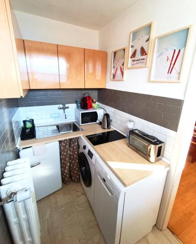 a small kitchen with a sink and a dishwasher at Maison Seguret 50mt from sky lifts in Sauze dʼOulx