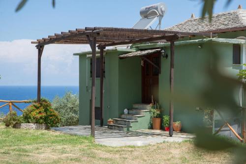 a green house with stairs and a pergola at Το καλύβι της γιαγιάς in Damouchari