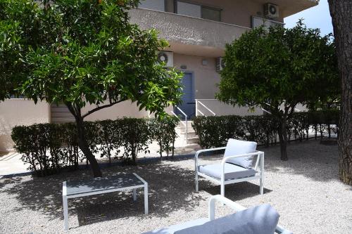 two chairs and a table in front of a building at Studios Αποστόλης Selianitika in Aígio