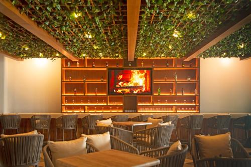 a restaurant with tables and chairs and a fireplace at Hotel Amares Acapulco in Acapulco