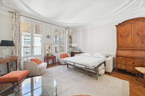 une chambre avec un lit et un salon dans l'établissement Veeve - Palatial by the Park, à Paris
