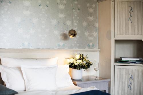 a bedroom with a bed and a vase of flowers at Hotel Fährhaus in Munkmarsch
