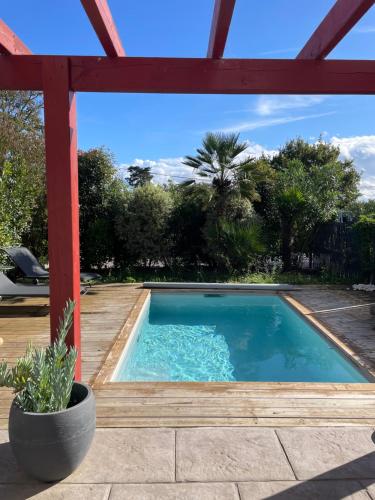 - une piscine dans une cour avec une pergola dans l'établissement Maison avec piscine - Bidart campagne proche plages, à Bidart