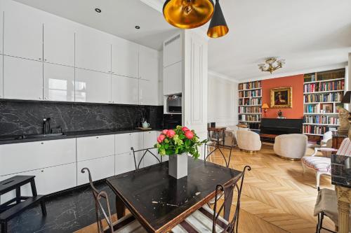 - une cuisine avec des placards blancs et une table fleurie dans l'établissement Veeve - Transcendent on the Trocadéro, à Paris