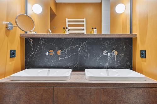 une salle de bain avec deux lavabos et un miroir dans l'établissement Veeve - Transcendent on the Trocadéro, à Paris