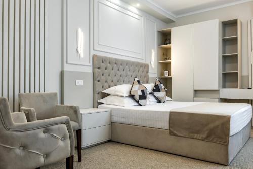 a bedroom with a bed and a chair at La Strada The Villa in Piteşti