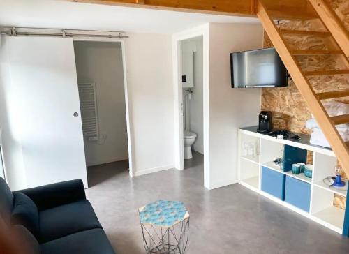 un salon avec un canapé et une télévision sur un mur dans l'établissement Cocon Urbain Mezzanine, à Talence