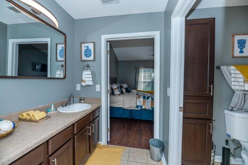 a bathroom with a sink and a bedroom at Stoney Oasis in Charleston