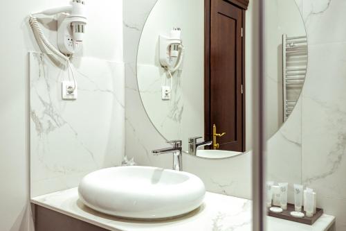 a bathroom with a white sink and a mirror at La Strada The Villa in Piteşti