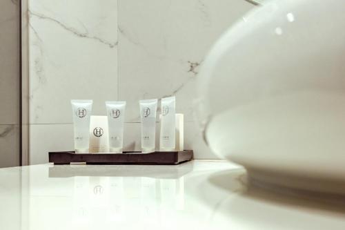 a row of white candles on a shelf in a room at La Strada The Villa in Piteşti