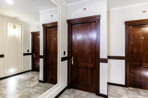 a hallway with wooden doors and a mirror at La Strada The Villa in Piteşti