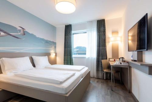 a hotel room with a bed and a desk at Best Western Hotel Kiefersfelden in Kiefersfelden