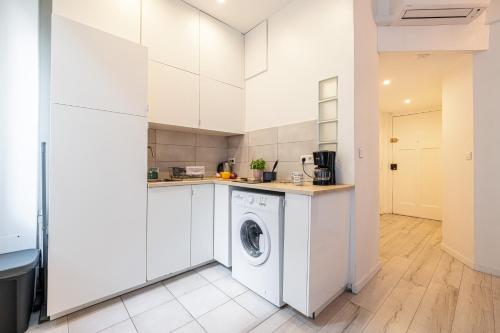 - une cuisine blanche avec lave-linge et sèche-linge dans l'établissement Appartement Shakespeare - Happy Rentals, à Nice
