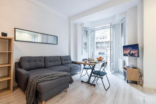 un salon avec un canapé et une table dans l'établissement Appartement Shakespeare - Happy Rentals, à Nice