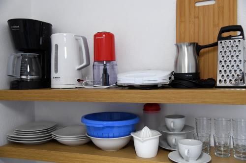 a shelf with cups and dishes on it at Studios Αποστόλης Selianitika in Aígio