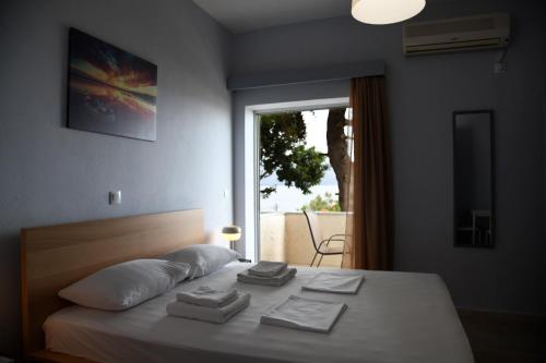 a bedroom with a bed with towels on it at Studios Αποστόλης Selianitika in Aígio