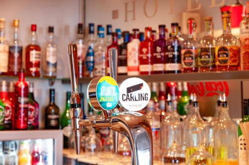 a bar with a faucet and many bottles of alcohol at Claxton Hotel in Redcar